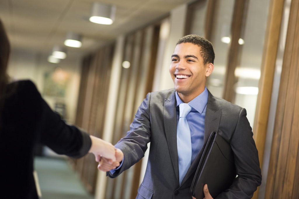 business professionals shaking hands in an office setting