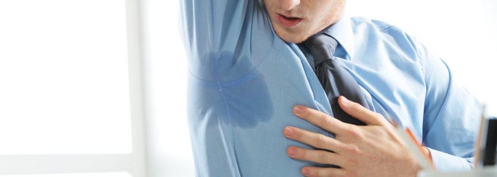 Businessman-looking-at-his-armpit-sweat-stain