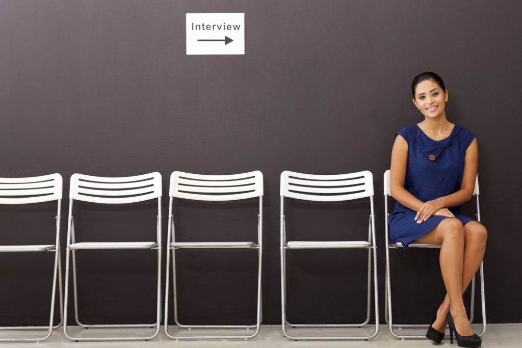 Young woman sitting, awaiting interview