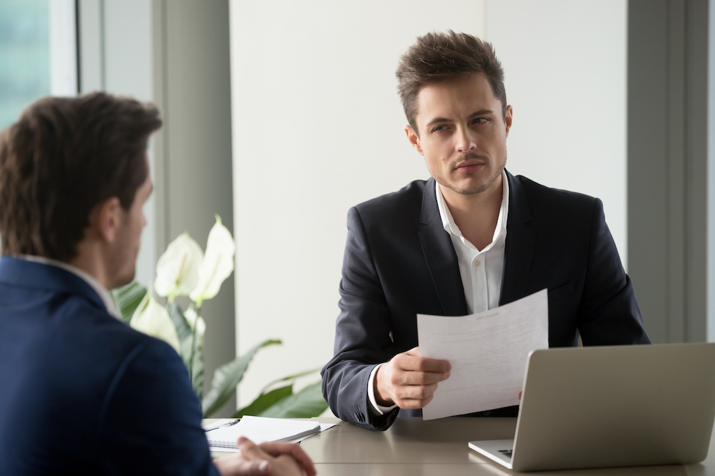 Businessman, recruiter reads bad resume during interview resume lies