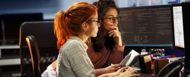 Two women coders collaborating on project