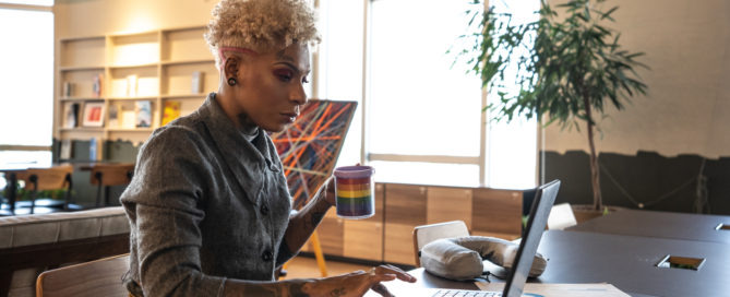 A woman holding a pride mug in support for the LGBT members in the office.
